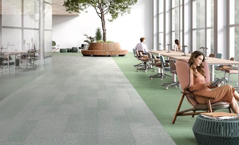 Une image de moquette avec des tons de gris et de vert dans un espace de coworking.